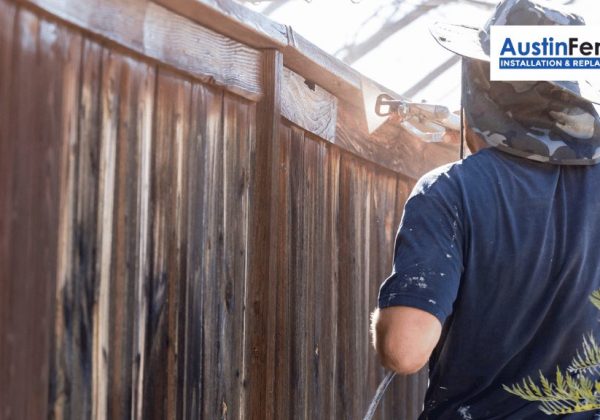 A person is painting a fence