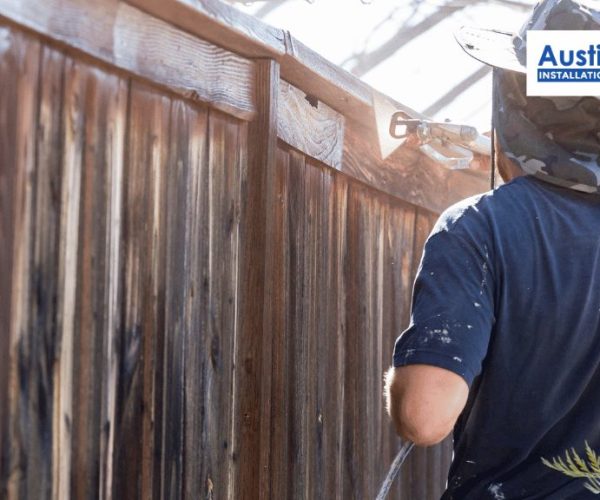 A person is painting a fence