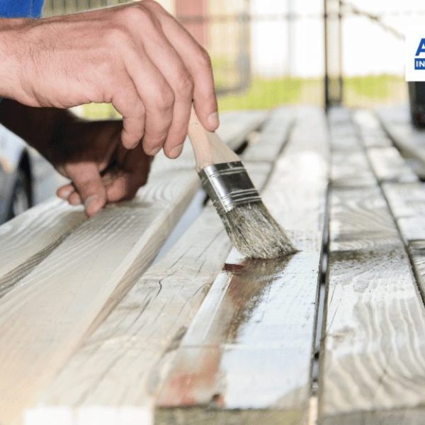 contractor staining a wooden panel
