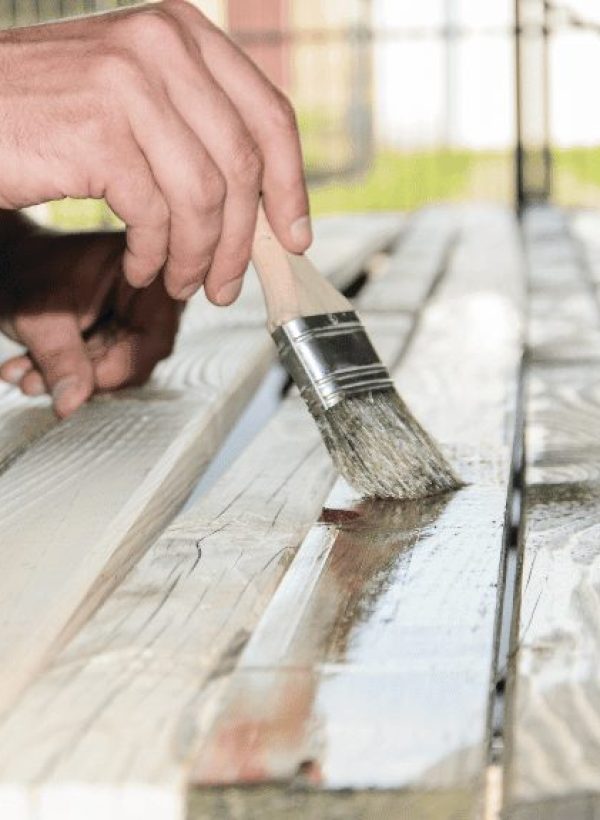 contractor staining a wooden panel